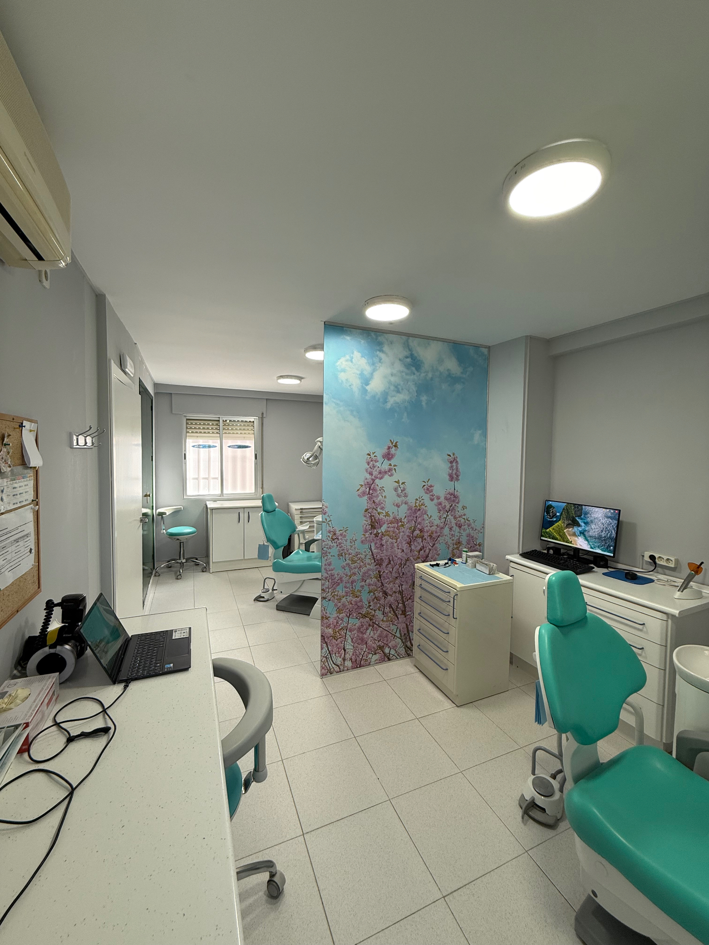 Consulta dental moderna de Élite Dental en tonos blancos y turquesa